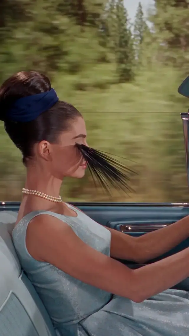 Audrey Hepburn Lookalike Driving Convertible With Windblown Eyelashes Transforming Into Halo In Vintage Technicolor